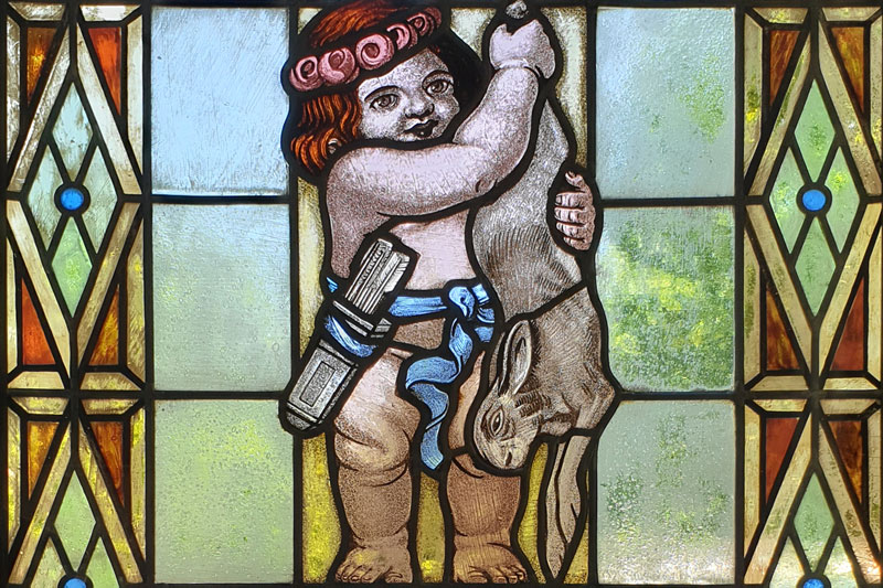 Historisches Buntglassfenster mit Putte