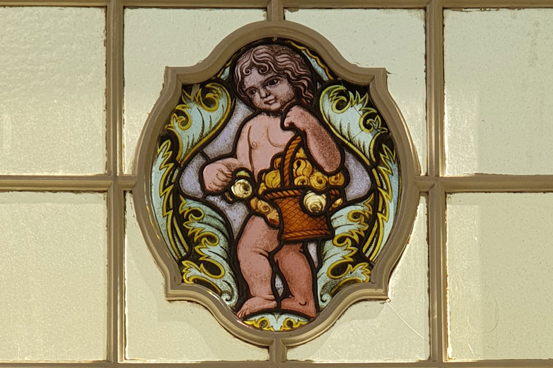 Historische Buntglasfenster mit Putte
